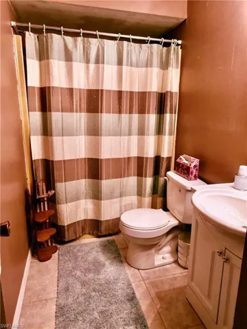 Full bath with vanity, a shower with curtain, and tile patterned flooring