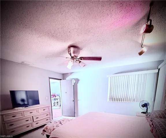 Bedroom with a textured ceiling and ceiling fan