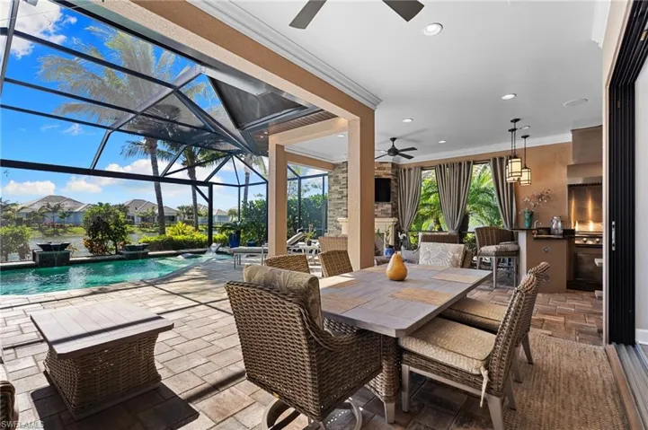 View of patio with a ceiling fan, outdoor dining space, an outdoor pool, a sunroom, and glass enclosure