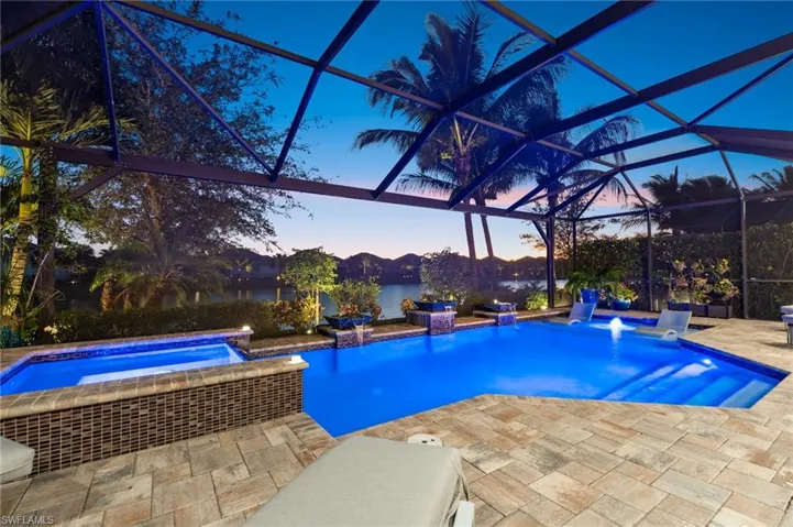 Integrated pool / spa with glass enclosure, a sunroom, and a patio