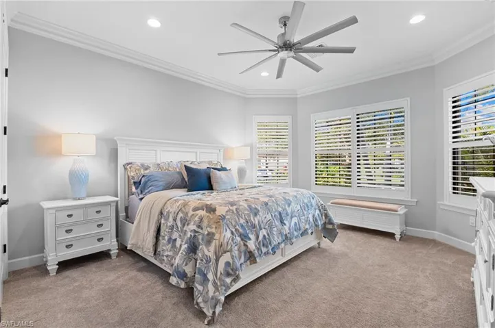Carpeted bedroom featuring ornamental molding, recessed lighting, and a ceiling fan