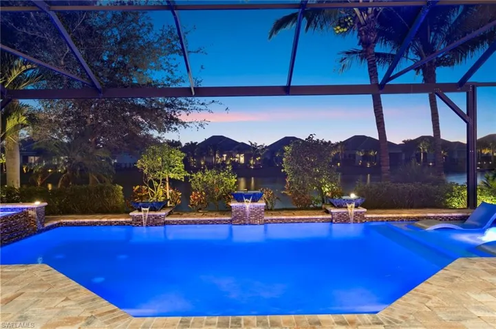 Pool at dusk featuring an outdoor pool and glass enclosure