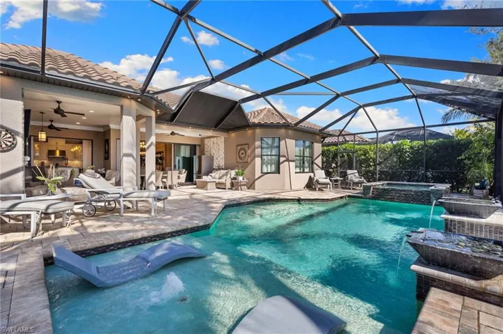 Combined pool / hot tub with a patio, a sunroom, and glass enclosure