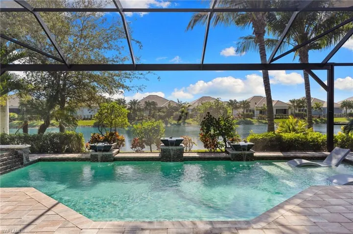 Swimming pool featuring glass enclosure, a residential view, and a water view