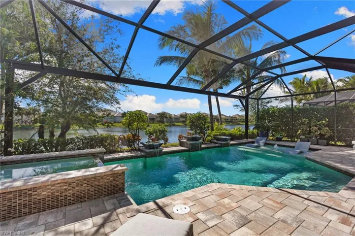 Integrated pool / spa featuring glass enclosure, a sunroom, a water view, a patio, and a residential view