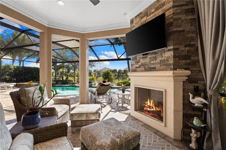 View of patio with an outdoor pool, a lanai, a sunroom, and an outdoor living space with a fireplace