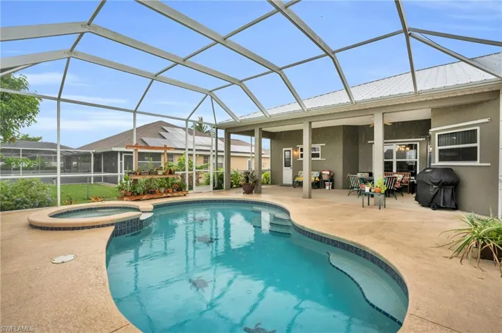 View of pool featuring an in ground hot tub, a patio area, glass enclosure, and area for grilling