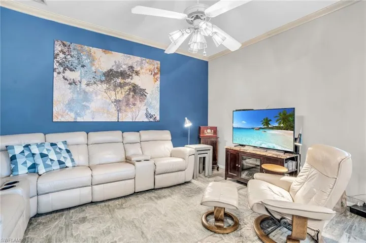 Living room with wood-type flooring, crown molding, and ceiling fan