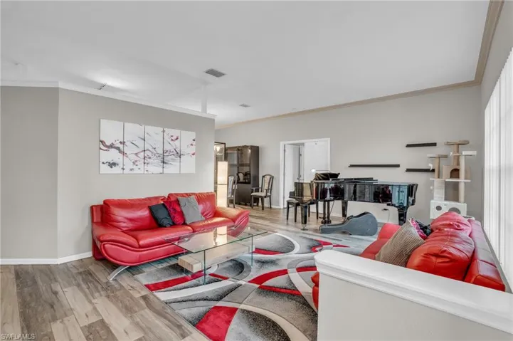 Living room with crown molding and wood-type flooring