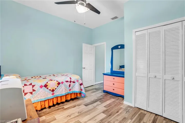Bedroom with a closet, hardwood / wood-style flooring, a towering ceiling, and ceiling fan