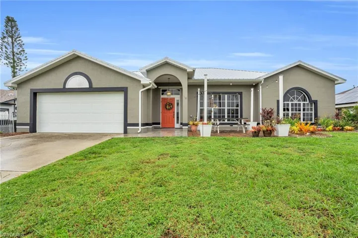Ranch-style home featuring a garage and a front yard