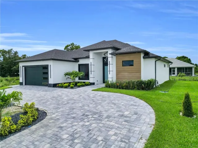 Prairie-style home with an attached garage, decorative driveway, stucco siding, and a shingled roof
