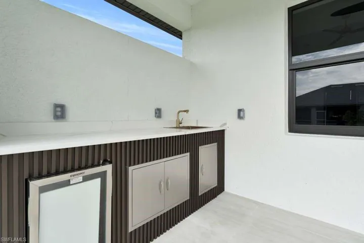Bar with light countertops and a sink