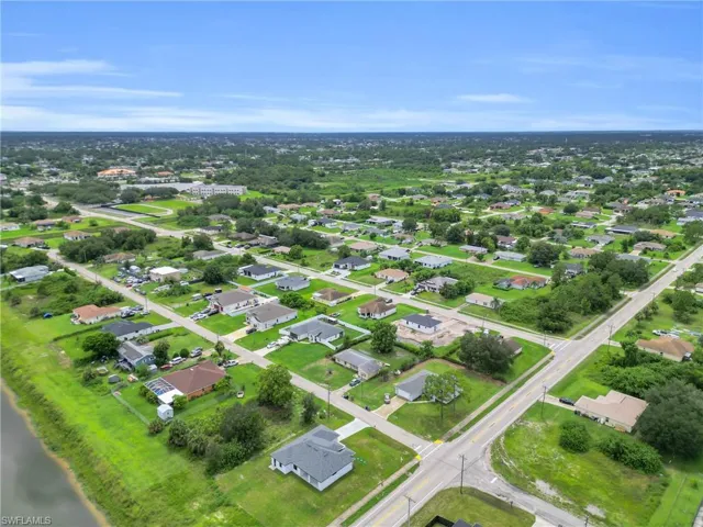 Aerial view of property and surrounding area with nearby suburban area