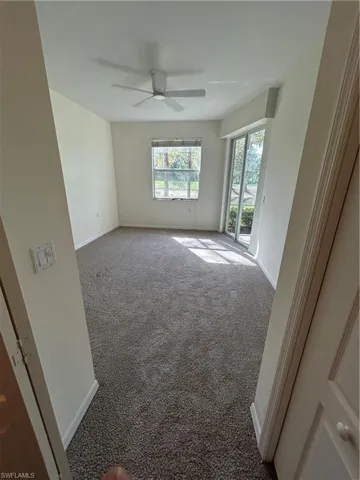 Empty room featuring carpet and a ceiling fan
