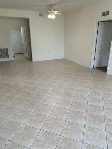 Featuring ceiling fan and light tile patterned floors