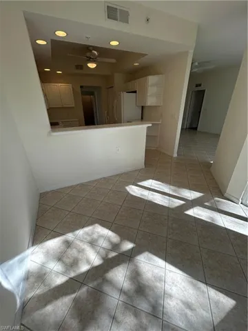 Kitchen with ceiling fan, light tile patterned flooring, a peninsula, and recessed lighting
