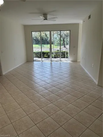 Unfurnished room with ceiling fan, plenty of natural light, and light tile patterned floors