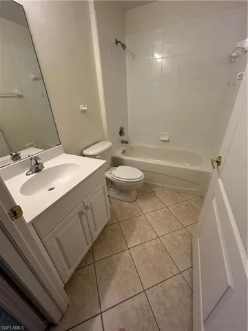 Bathroom featuring vanity, washtub/ shower combination, and light tile patterned floors