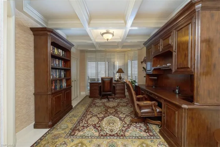 Office space featuring coffered ceiling, beam ceiling, and crown molding