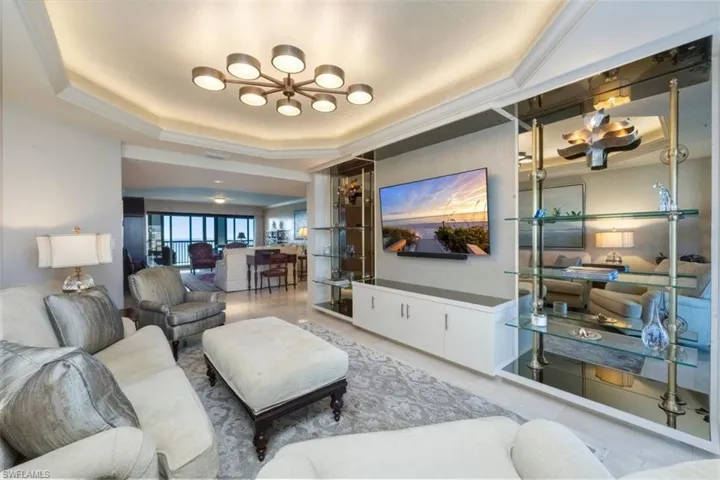 Living area featuring a chandelier and a raised ceiling