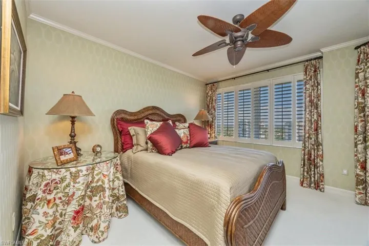Bedroom with wallpapered walls, crown molding, a ceiling fan, and carpet floors