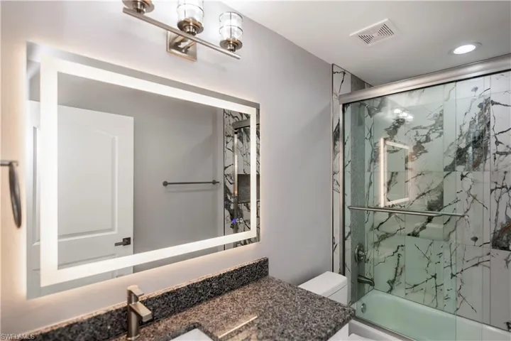 Full bathroom featuring vanity and enclosed tub / shower combo