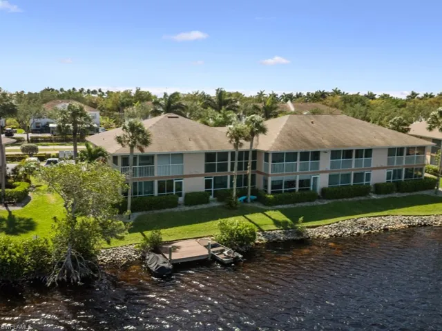 Rear view of property with a yard and a water view