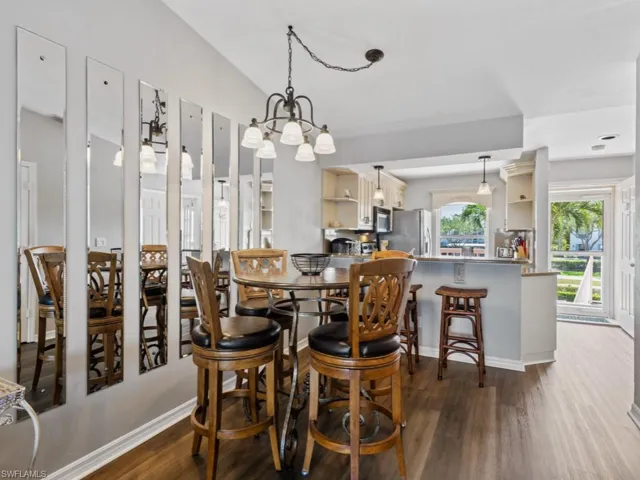 Dining area featuring baseboards, an inviting chandelier, and wood finished floors
