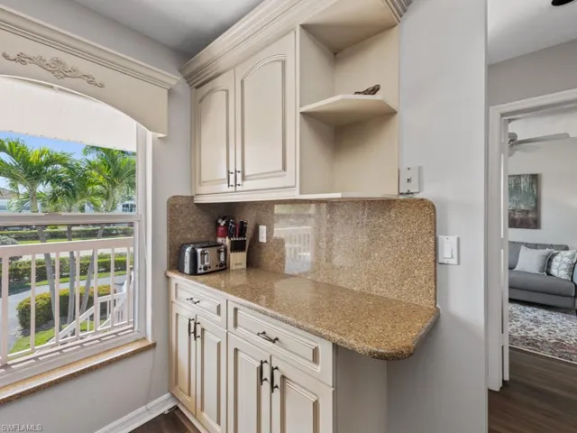 Kitchen with tasteful backsplash, dark wood-style flooring, cream cabinets, open shelves, and ceiling fan