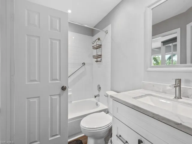 Bathroom featuring bathing tub / shower combination, vanity, toilet, and wood finished floors