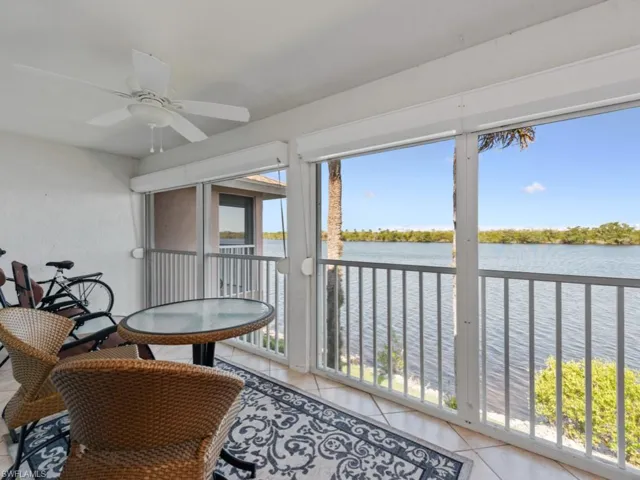 Sunroom featuring a water view, plenty of natural light, and ceiling fan