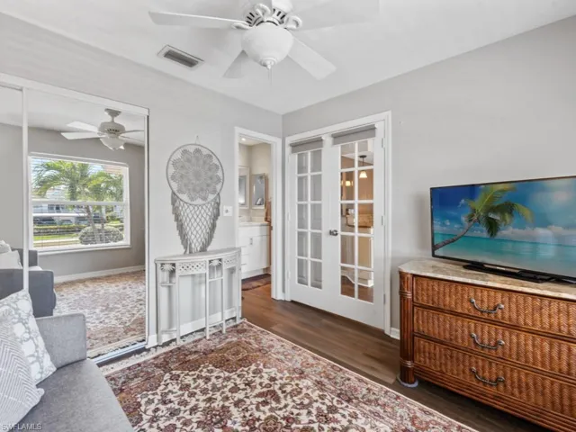Living area with ceiling fan, visible vents, wood finished floors, french doors, and baseboards