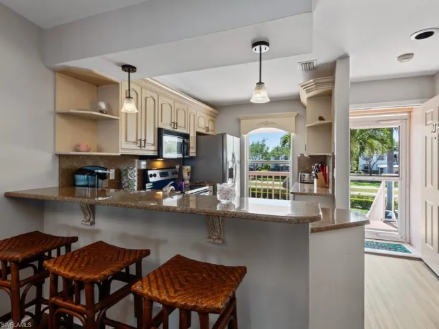 Kitchen featuring a peninsula, appliances with stainless steel finishes, open shelves, and visible vents