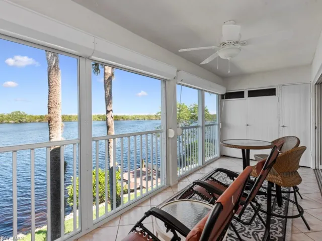 Sunroom / solarium with ceiling fan and a water view
