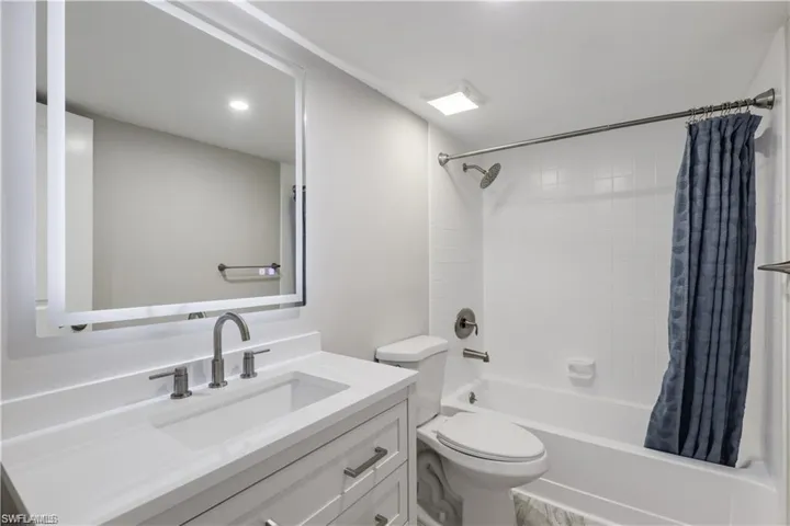 Full bathroom featuring vanity, toilet, and shower / bath combination with curtain
