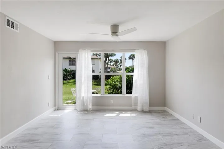 Unfurnished room with plenty of natural light, ceiling fan, and light tile patterned floors