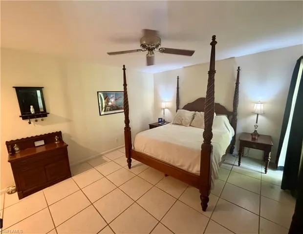Spacious room featuring neutral wall tones, large format tile flooring, and a ceiling fan with integrated lighting