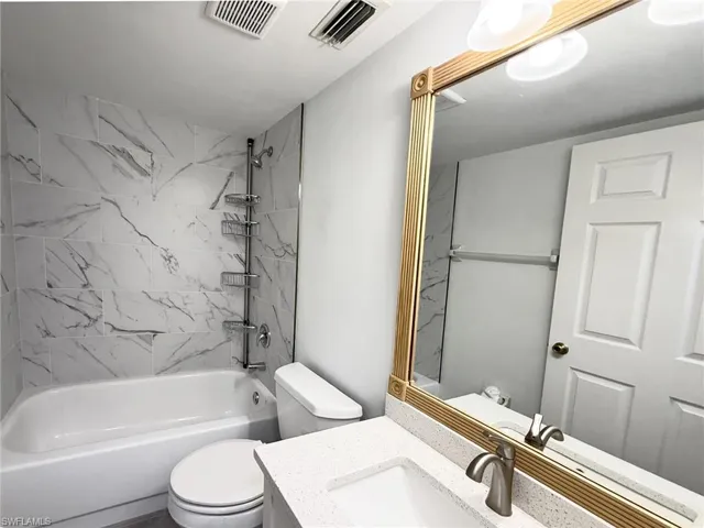 Modern tiled tub surround; vanity and lighting in the guest bath.
