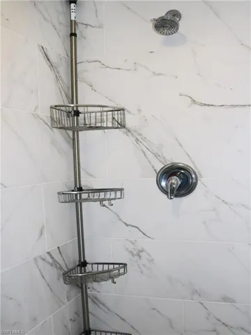 Elegant tiled shower with newer fixtures in the owner's bath.