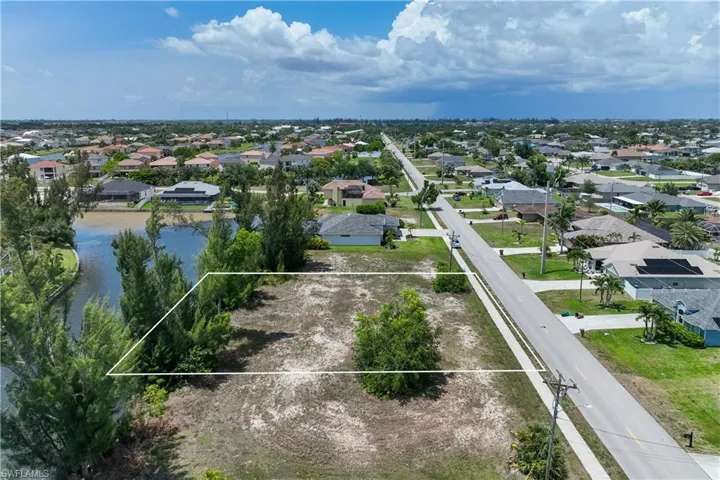 Aerial view of residential area featuring property parcel outlined and a large body of water