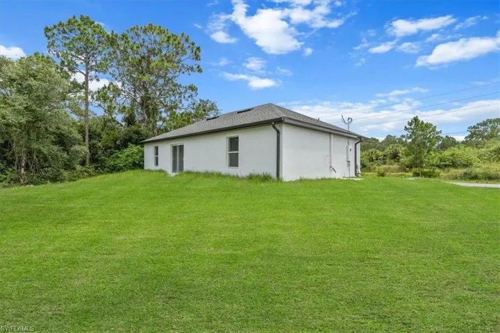 View of home's exterior featuring stucco siding and a lawn