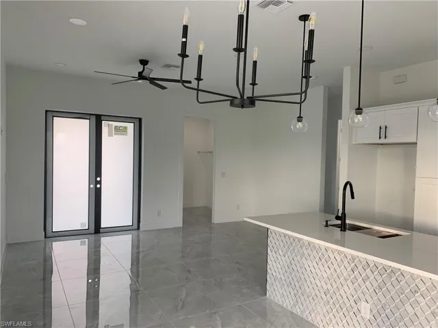 Front door, entrance to laundry, living room + partial kitchen view