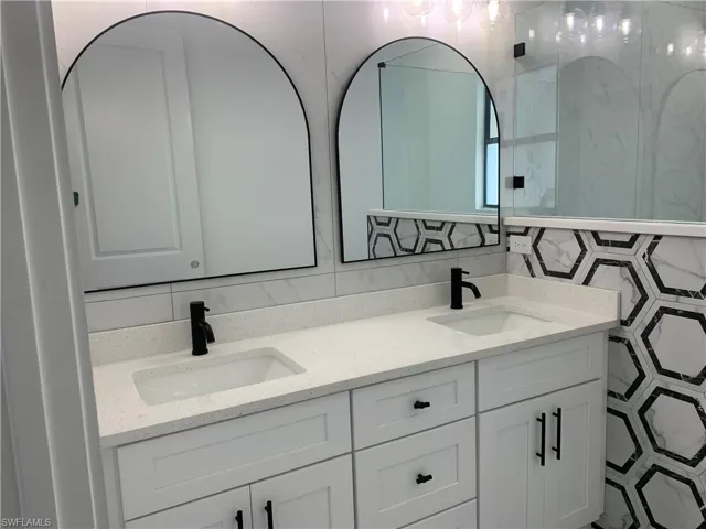 Custom double sinks with arched mirrors + black finishes