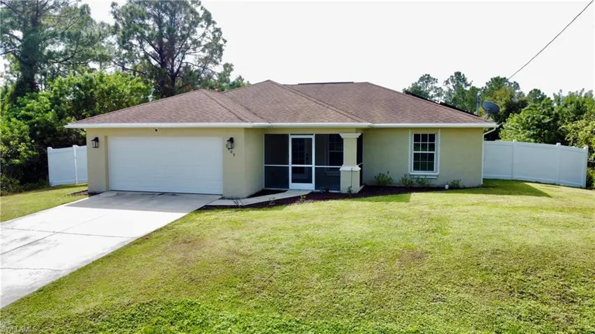 Ranch-style home featuring a front yard and a garage