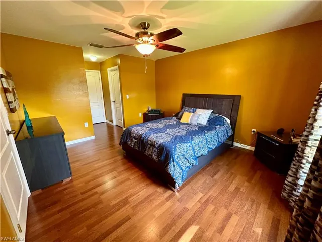 Bedroom with ceiling fan and wood-type flooring