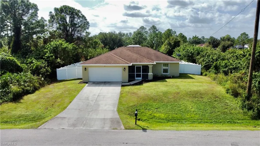 Single story home featuring a front yard and a garage