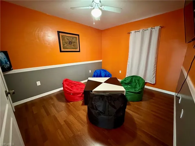 Living area with wood-type flooring and ceiling fan