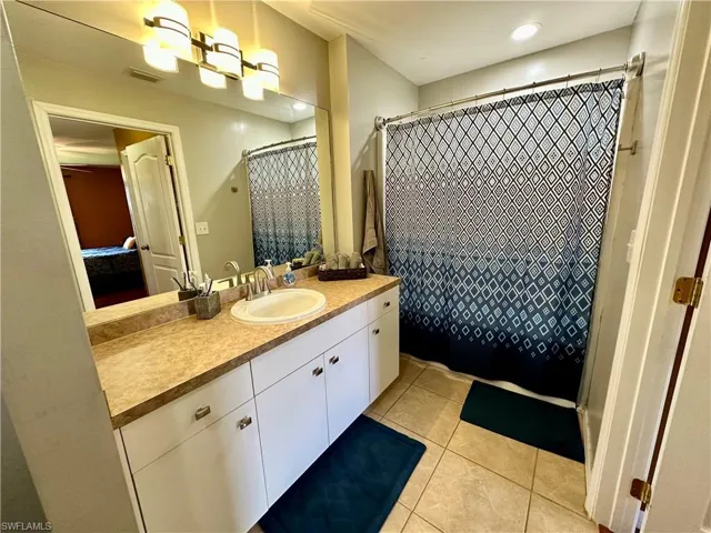 Bathroom with a shower with curtain, vanity, and tile patterned floors