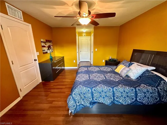 Bedroom featuring ceiling fan and dark hardwood / wood-style floors